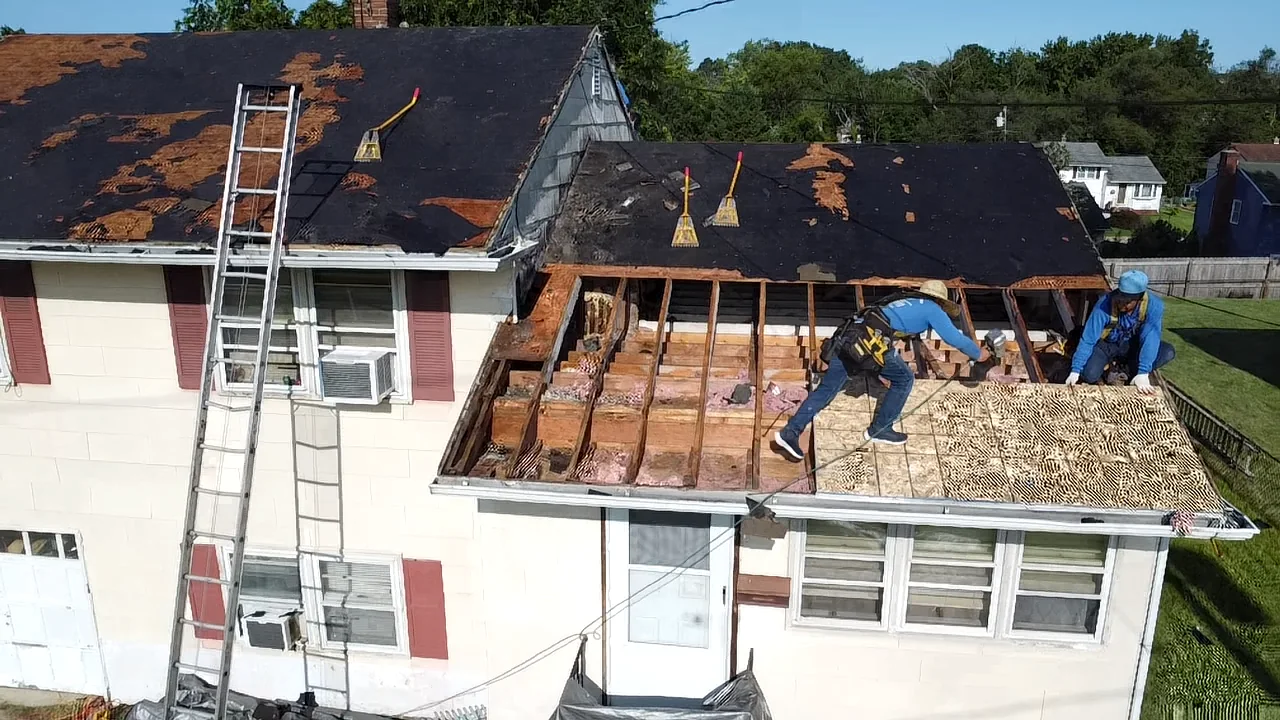 Roofing crew working on a home with ladders in place