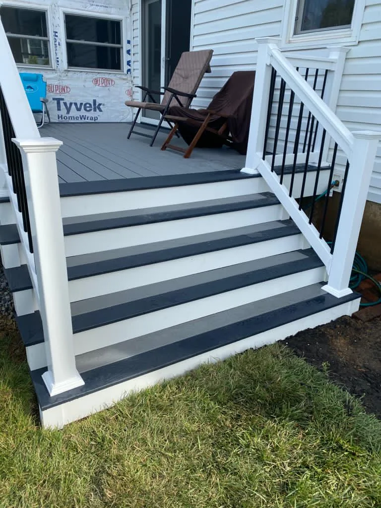 White-railed outdoor staircase beside a home