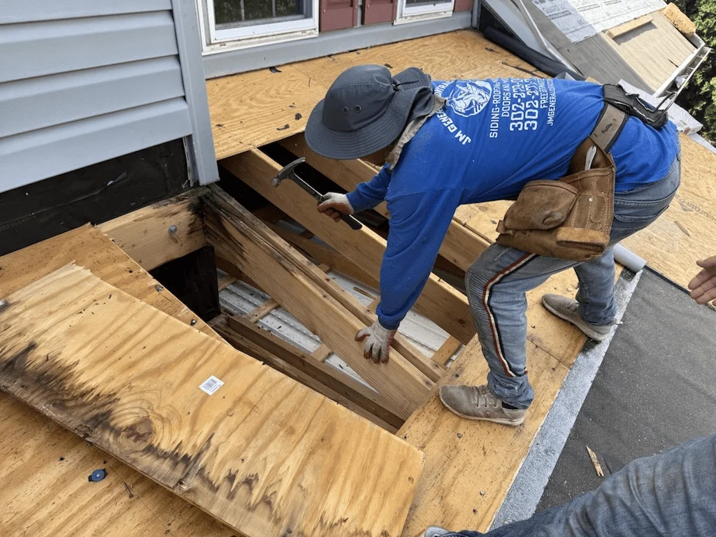 Worker repairing roof sheathing