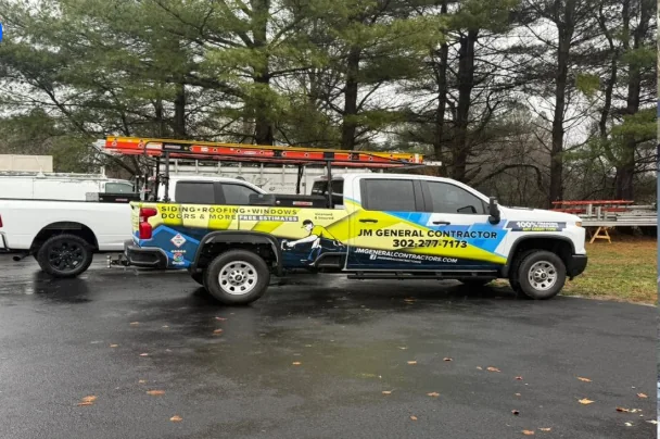 JM General Contractors work vehicles parked at a project site