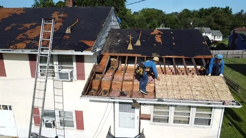 Roofing crew working with ladders on a two-story home