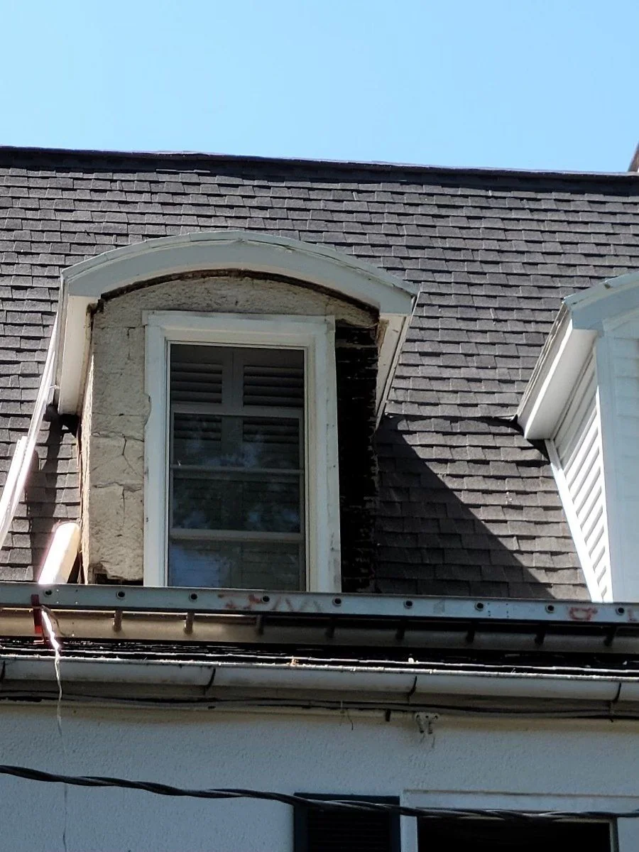 Dormer and window detail on a shingled roof