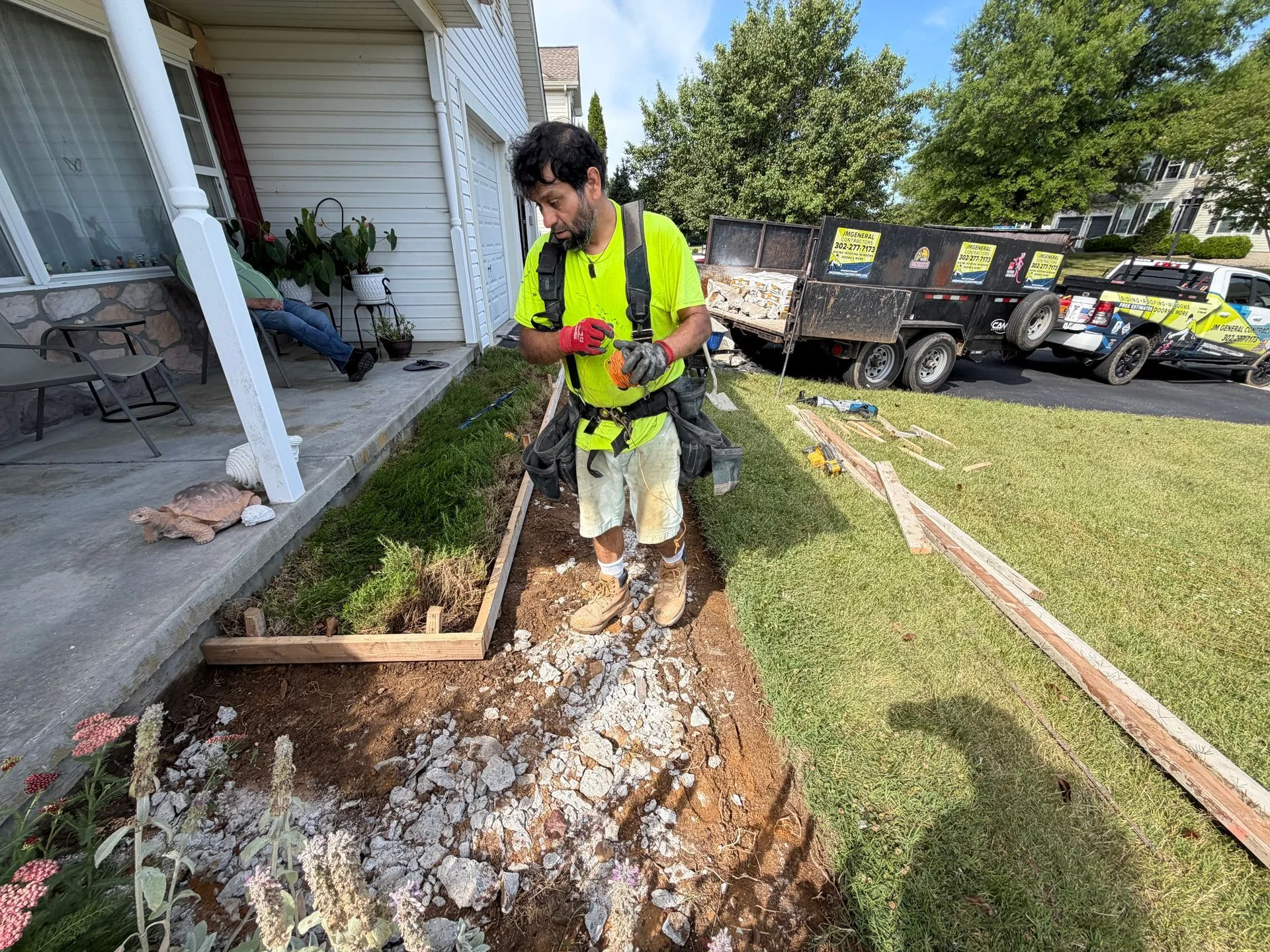 Worker preparing the edge of a concrete walkway