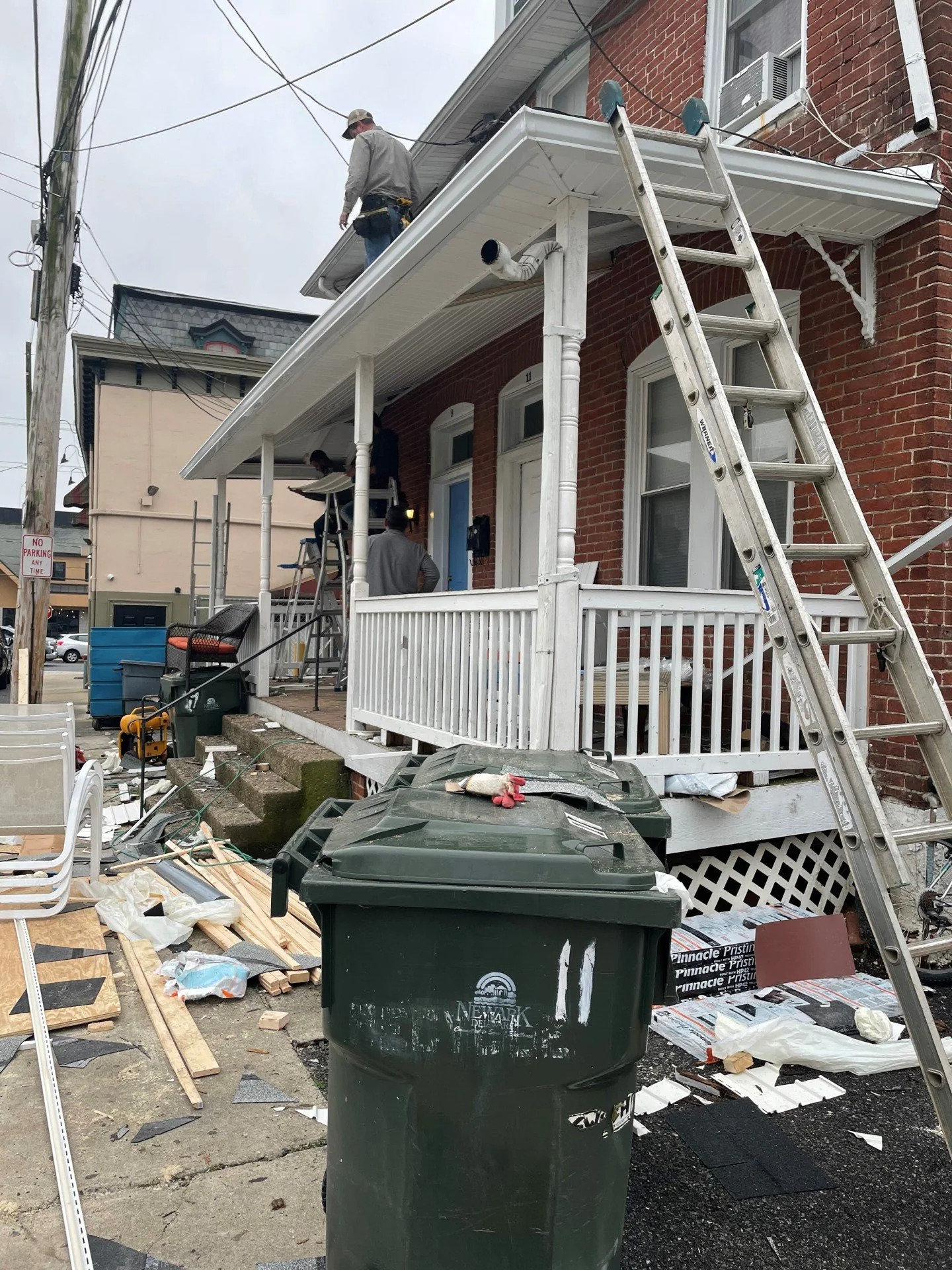 Porch renovation with ladders and materials on site